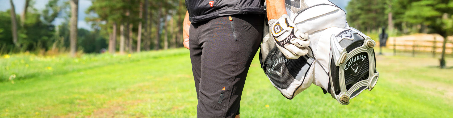 Närbild på Ez-Dry Shorts från Bright Equipment®, burna av en man med golfbag på ryggen.