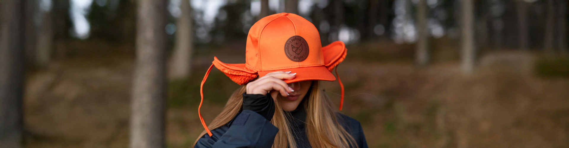 En ung söt flicka med en för stor Alpha Cap från Bright Equipment® neddragen över ögonen.