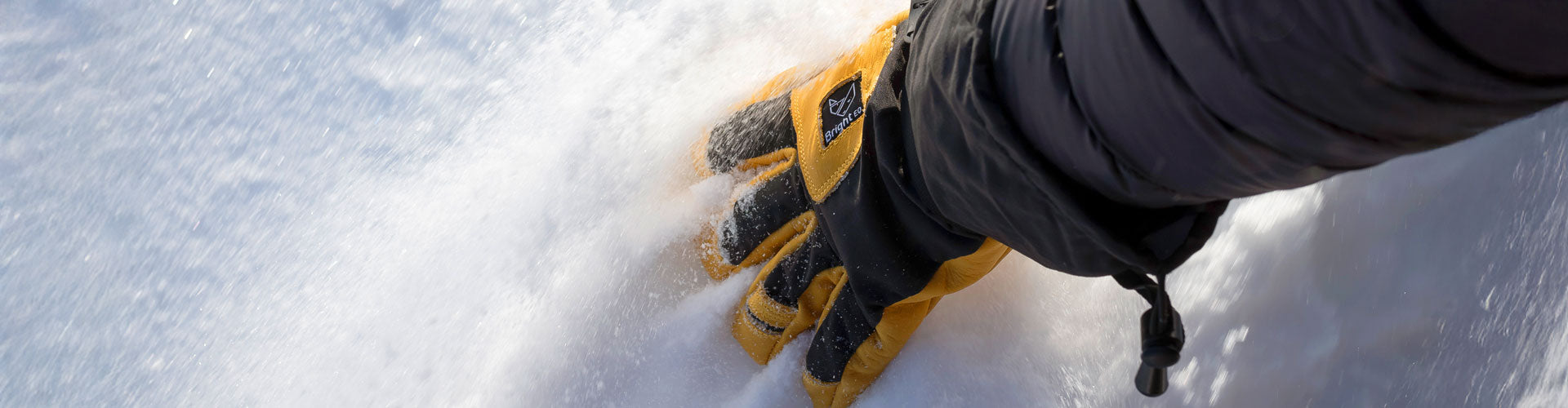 Bild på Tundra Glove från Bright Equipment® fingrar som dras genom mjuk snö